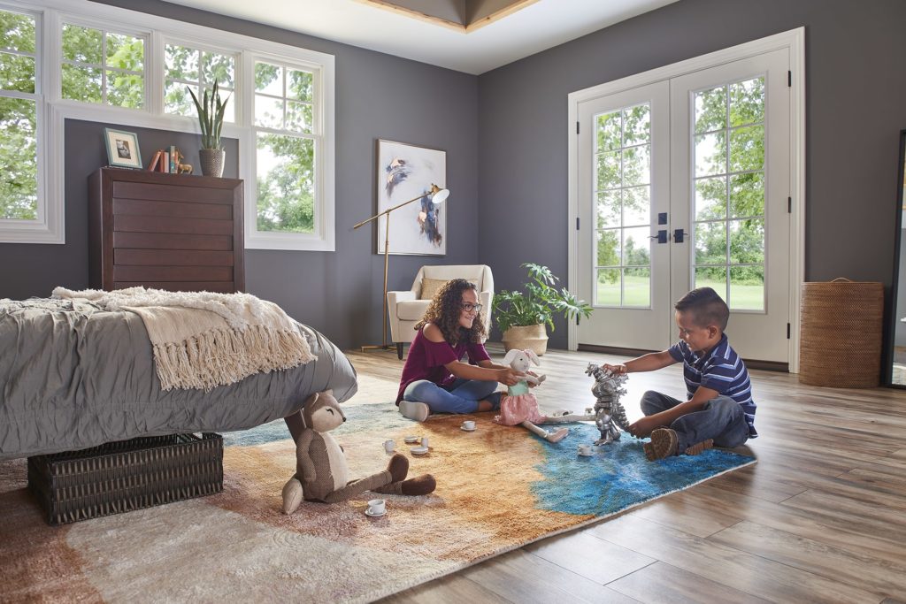 children playing on the floor in front of French doors