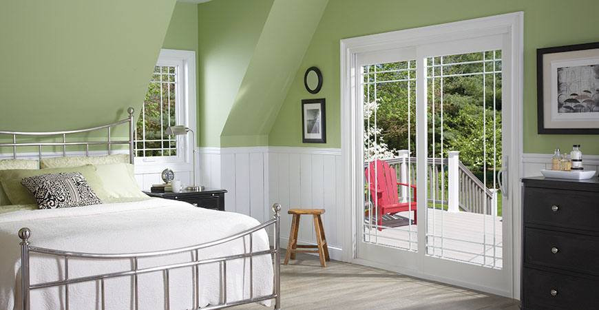 Bedroom with green walls and a patio door.